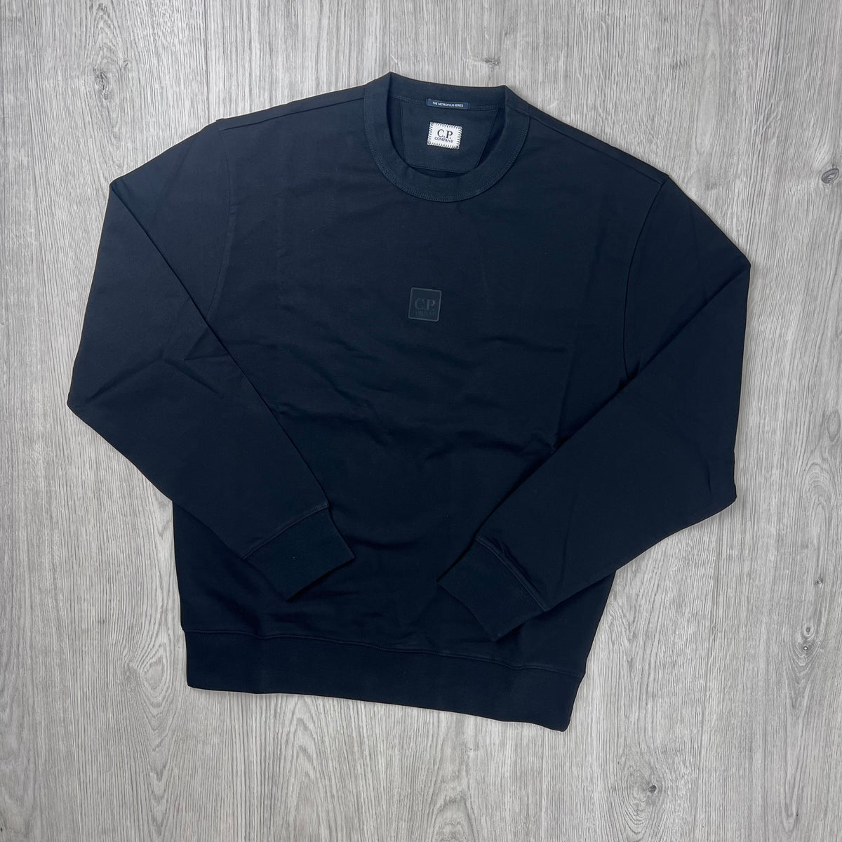 The front view of a CP Company Metropolis Series Stretch Fleece Sweatshirt with both arms folded.