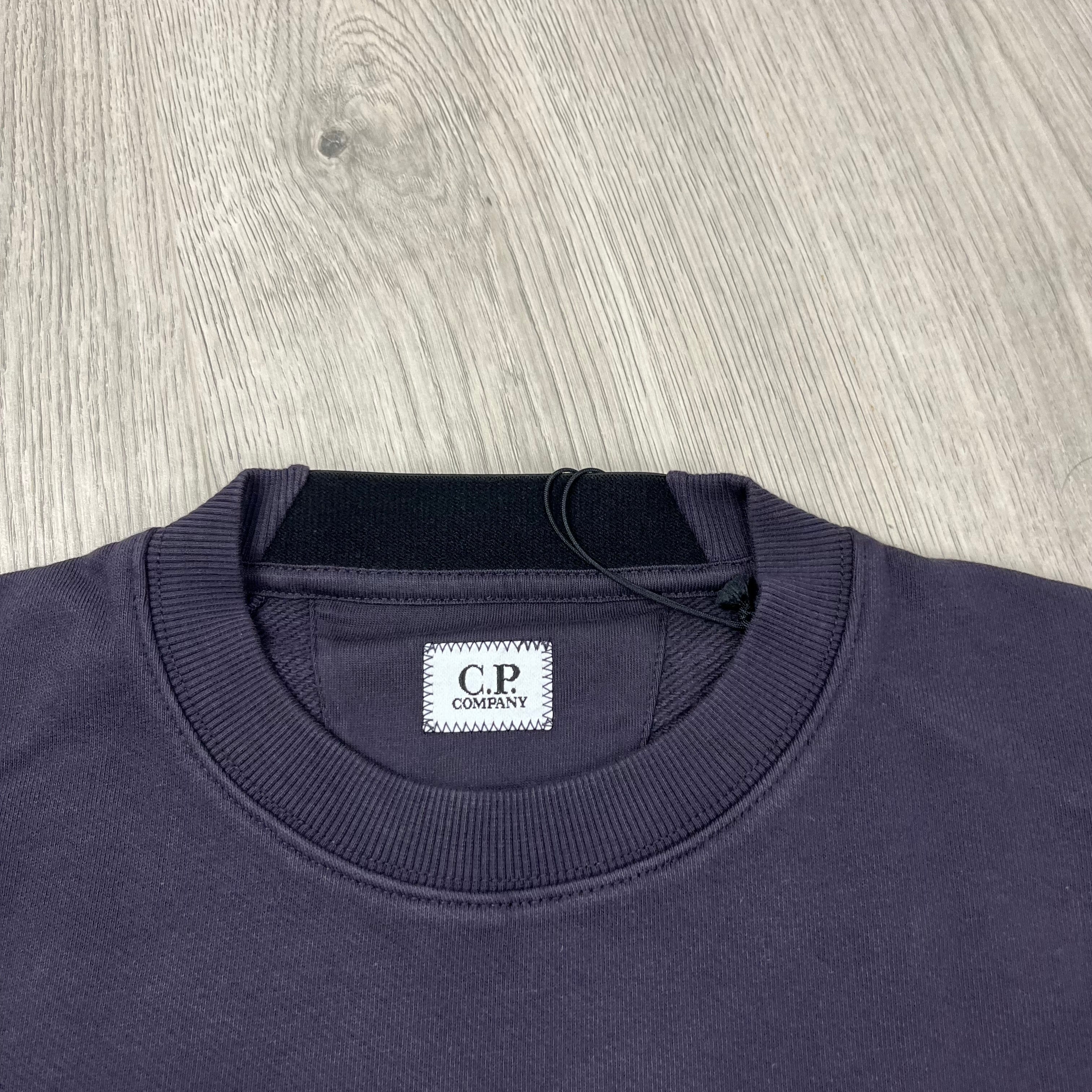 CP Company Diagonal Raised Fleece Crew Neck Lens Sweatshirt in Nightshade Purple. On sale at Open Attire.