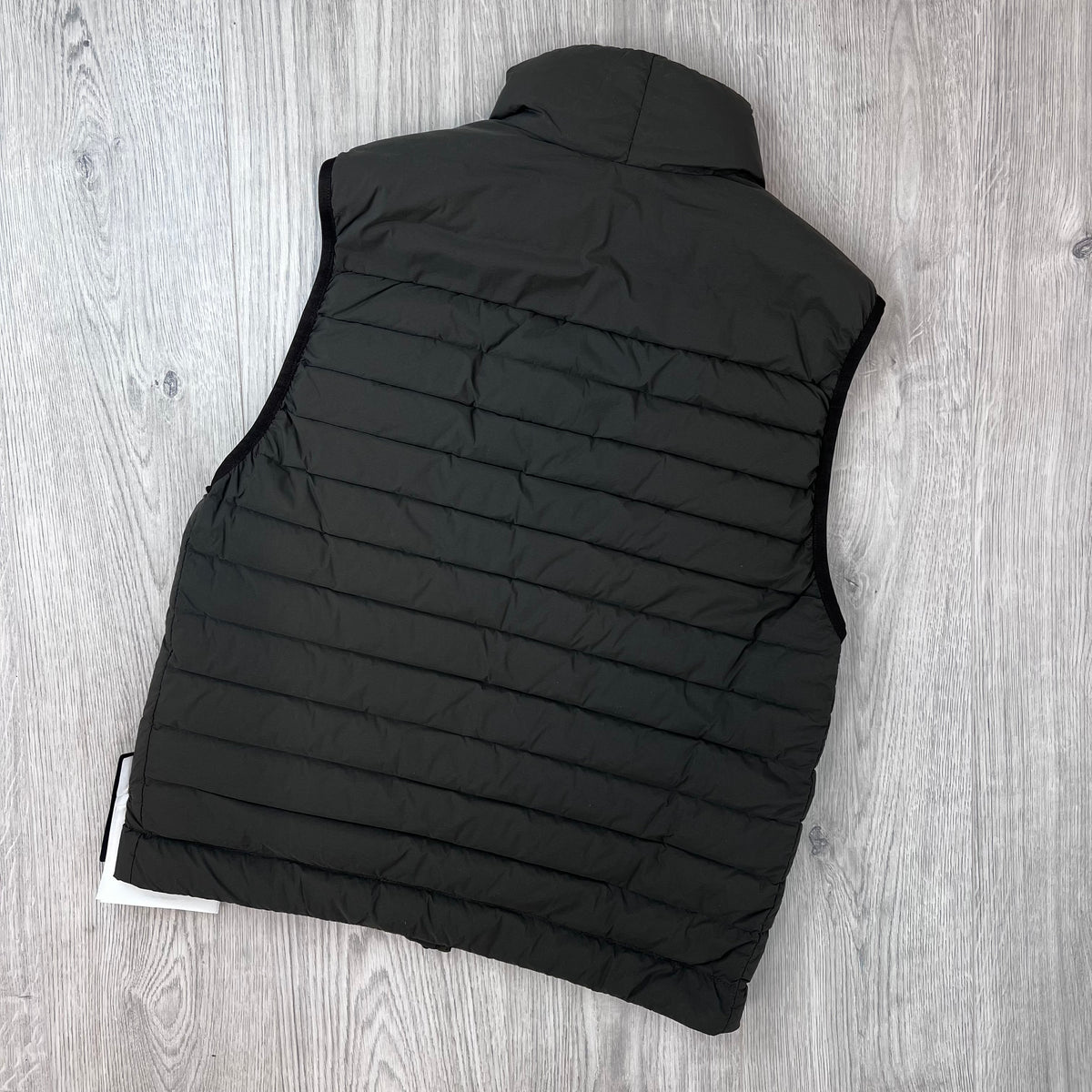 Rear view of the Stone Island Seamless Tunnel Nylon Down-TC Down Gilet in Coal Grey. 