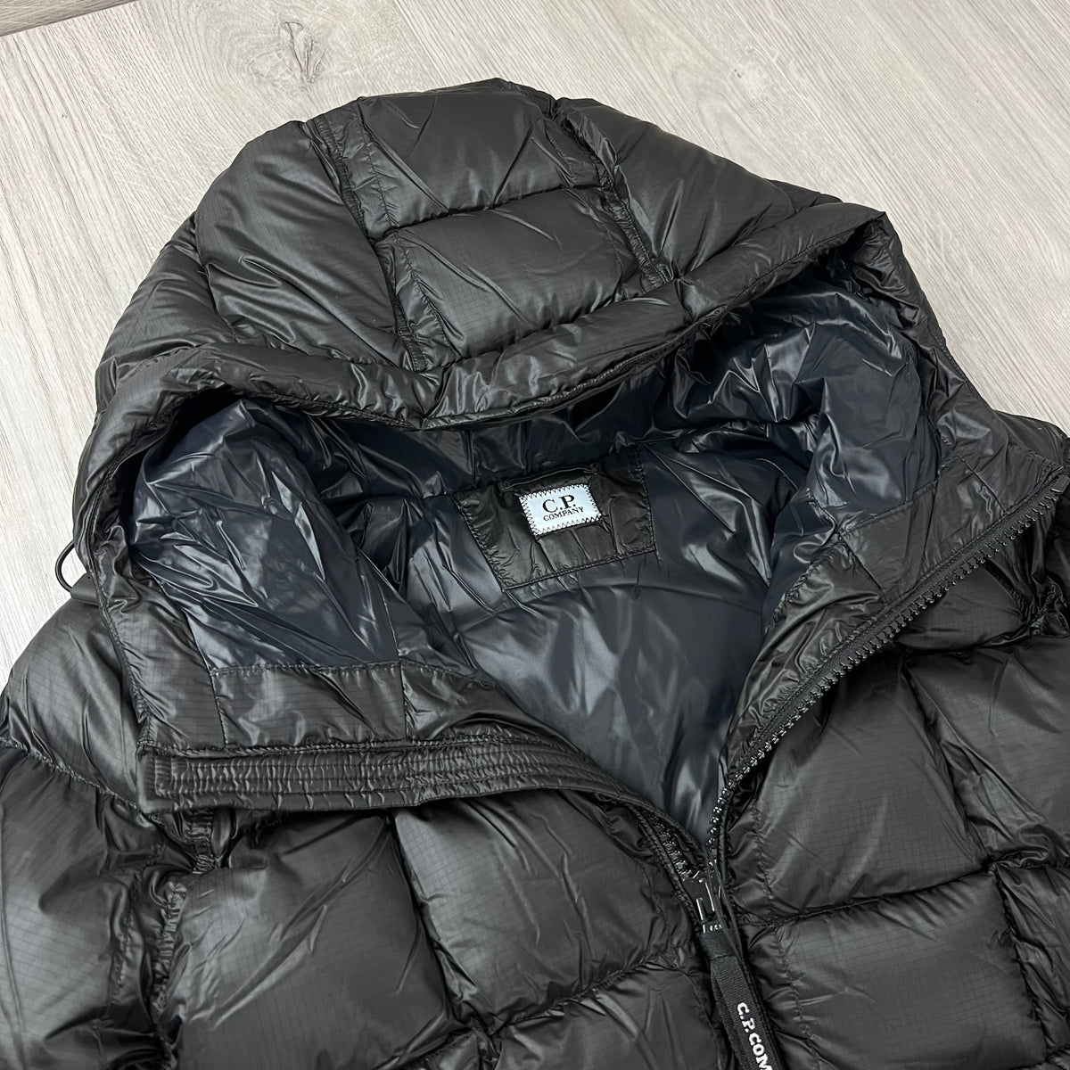 A close up view of the hood and neck of a CP Company D.D. Shell Hooded Down Jacket in Black. 